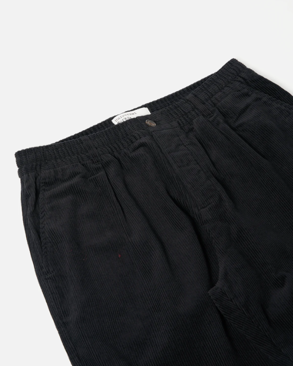 UNIVERSAL WORKS PLEATED TRACK PANT IN BLACK CORD