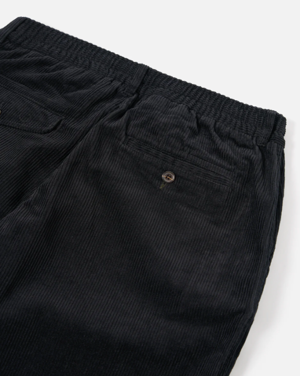 UNIVERSAL WORKS PLEATED TRACK PANT IN BLACK CORD