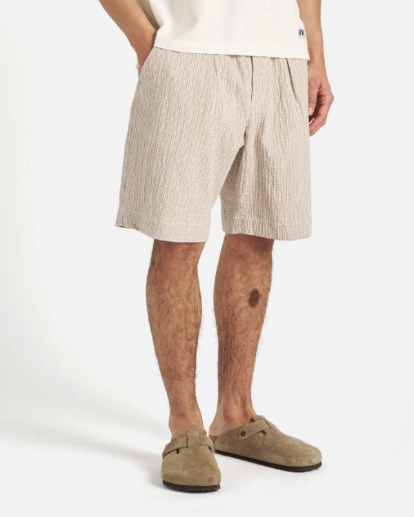 UNIVERSAL WORKS PLEATED TRACK SHORT IN ECRU/SAND OSPINA CHECK COTTON