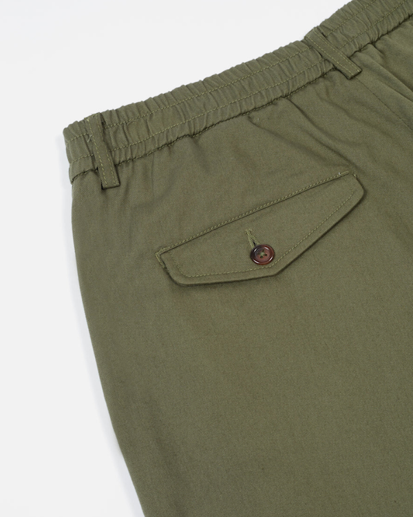 UNIVERSAL WORKS PLEATED TRACK PANT IN LIGHT OLIVE TWILL